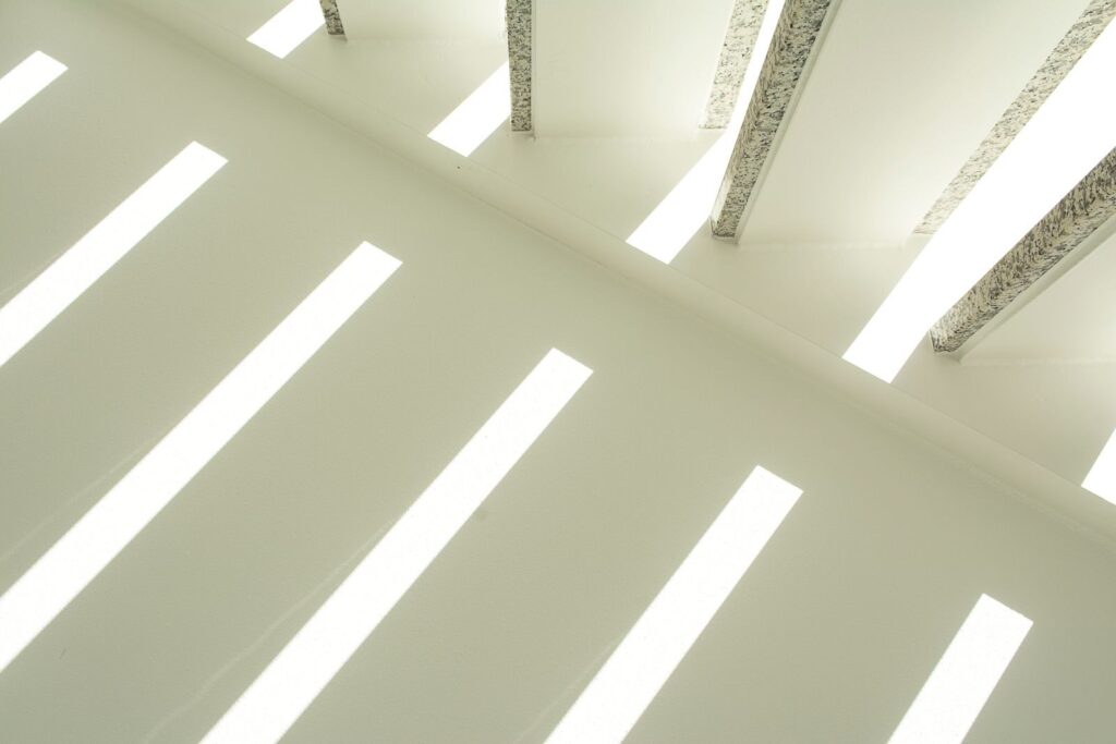 Abstract view of a ceiling with linear light beams creating a geometric pattern.
